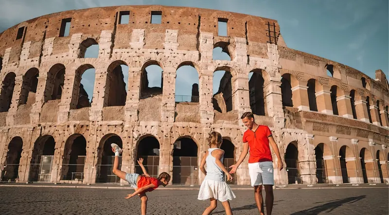 Dad and two girls playing and laughing outside the Colosseum